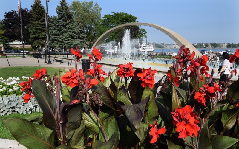 Flower beds and a fountain arch in a waterfront park in Kingston